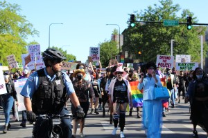 Protesters march past a Chicago Police officer during Sunday's Drag March for Change. | Jake Wittich/Block Club Chicago