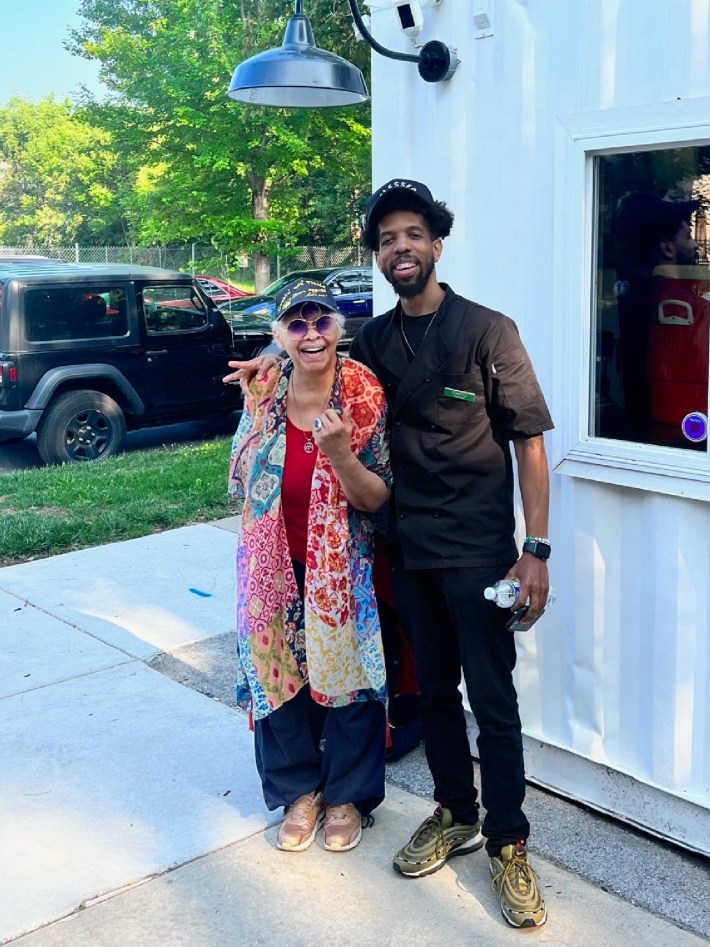 7323 Chicago Café owner Marquinn Gibson (right) poses with a customer outside the café, 6600 S. Woodlawn Ave.